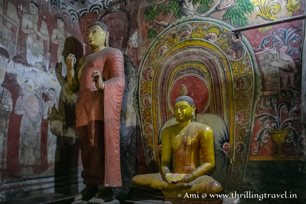 Statue of Ananda - Buddha's disciple against the vibrant Dambulla rock paintings